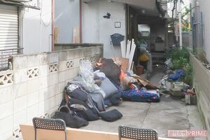 放火されたアパート（奥）。窓は開け放たれ、家財道具は外に出された