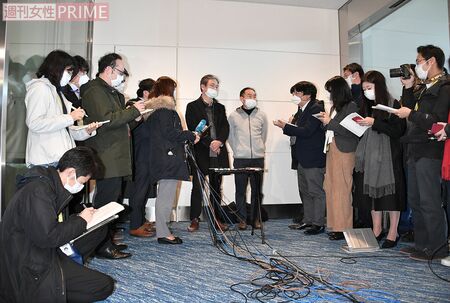 第1便のチャーター機で武漢から帰国した日本人男性らの会見。周囲を取り囲む報道陣たちもマスク姿だった（1月29日）