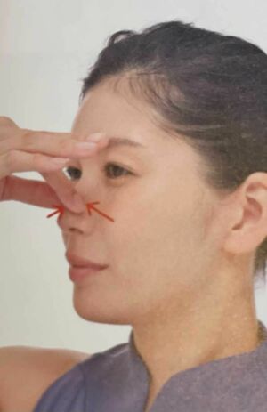 「鼻筋のリンパケア」（1）右手の親指と人さし指で小鼻のあたりを軽くはさみ、皮膚をやさしく寄せ、引っ張って戻す