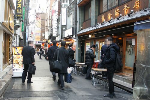 午後3時に開店した東京・新橋の居酒屋前には入店待ちのサラリーマンの姿も（2月24日夕）