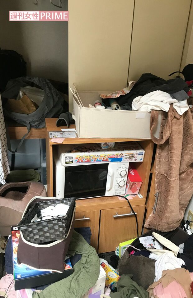 電子レンジの上に人生ゲーム。部屋は物であふれかえっていた