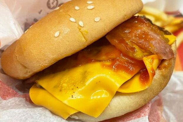 バーガーキングのダブルベーコンチーズバーガー（520円）。まるでビーフパティを包み込むヴェールのようなチーズが2枚も重なっていて、ベーコンと相まってジューシーさUP。フライドポテトをチーズの上にサンドして食べてもおいしい（筆者撮影／東洋経済オンライン）