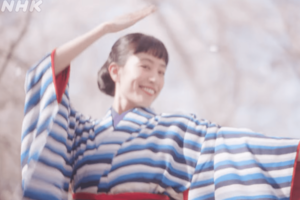 『咲き誇れ』。満開の桜の中で、石橋が笑顔で踊るタイトル映像が可愛いと話題に(NHK公式より)