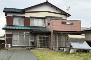 事件現場となった丸林榮子さん、哲也容疑者の自宅。庭先にはデイサービスの車が立ち寄るようになっていたという