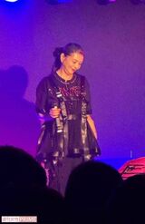 全身黒のコーデのシックな服にチャーミングな笑顔が映える