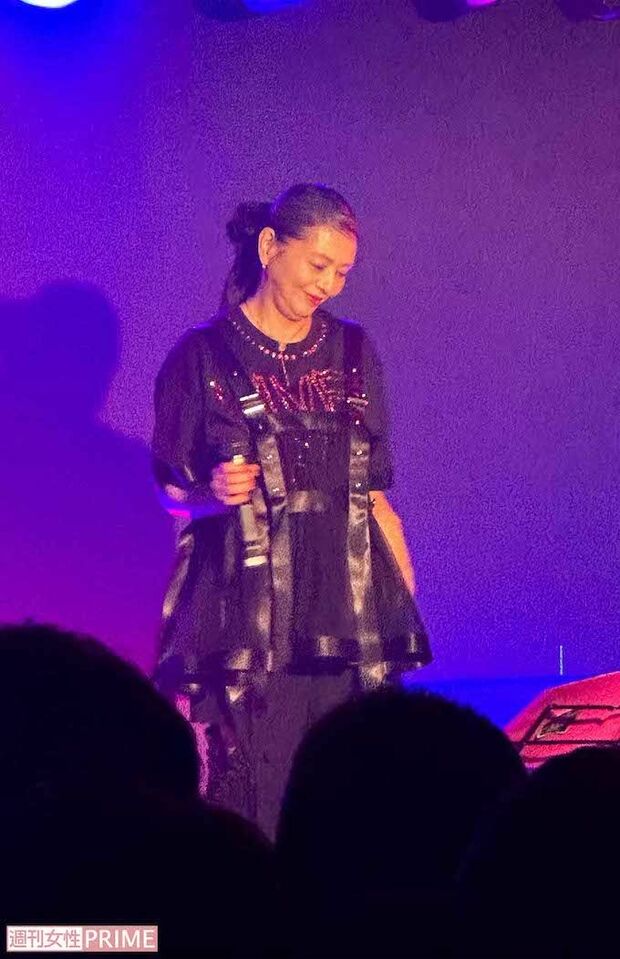 全身黒のコーデのシックな服にチャーミングな笑顔が映える