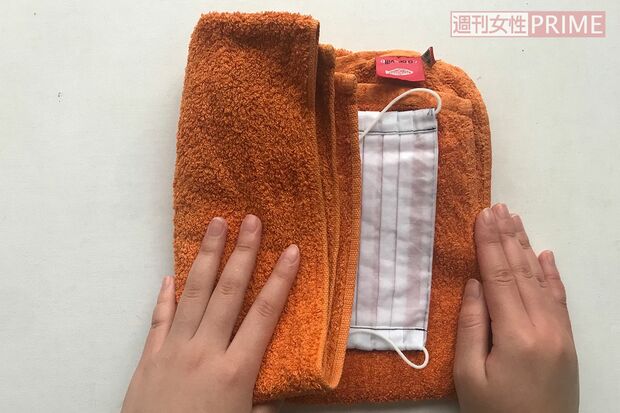 (5)清潔なタオルにマスクをのせてはさみ、軽くたたいて水けをきる。