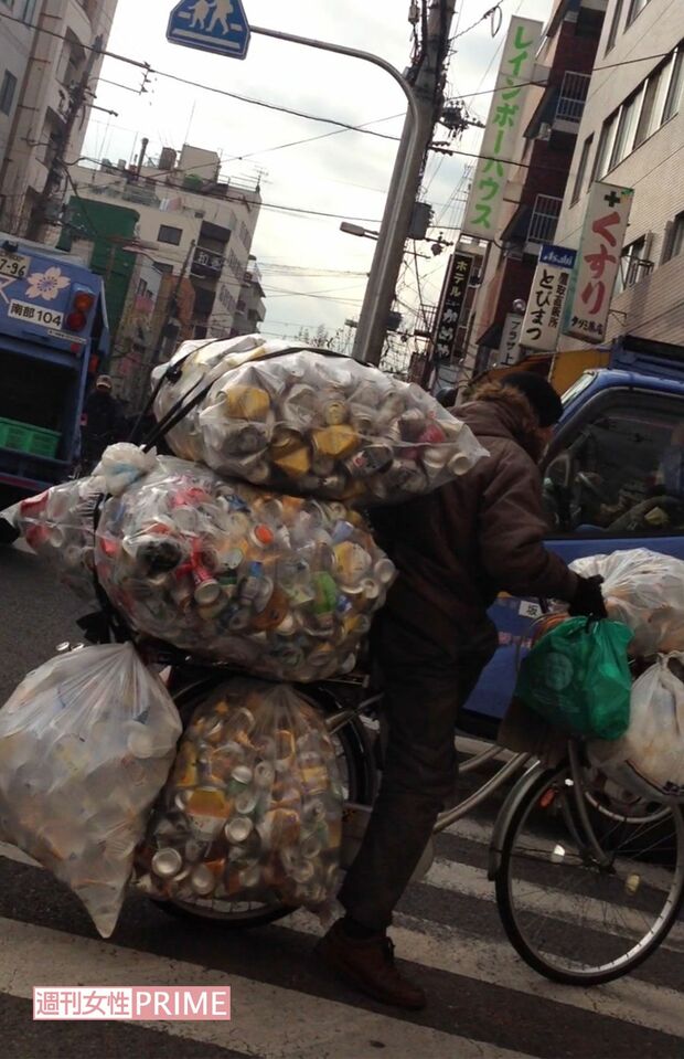 大量の空き缶を運ぶホームレス
