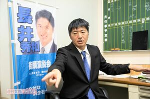 議員室で取材に応じる長井秀和