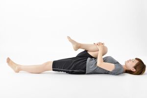 夜は、ストレッチや軽めの筋肉トレーニングを。あおむけに寝て、片ひざを両腕で抱え、息を吐きながら胸に引き寄せる。腰の筋肉が伸びるのを感じ10〜20秒間キープ。血行が良くなり心地よく眠れる効果も。継続が大事! ※写真はイメージです