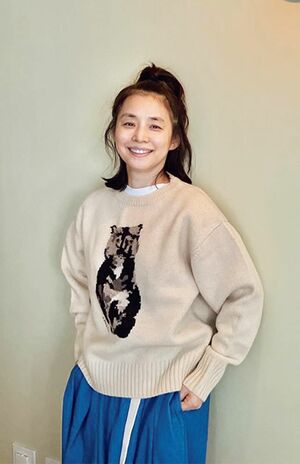 白Tに猫のイラスト入りニットを重ね、大人のリラックスムード漂う石田ゆり子さん(56歳、本人Instagramより)