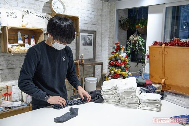 洗濯代行サービスを広く認知してもらうため、店内でたたむ作業を行う店員の姿も
