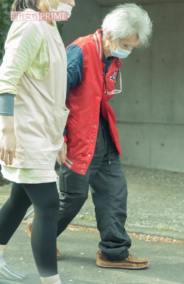 4月上旬、家政婦らしき女性に付き添われて自宅周辺を散歩する小澤