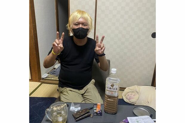 黒マスクでダブルピース。テーブルにはミルクティー2リットルとタバコ、ルイ・ヴィトンのキーケースが（本人のSNSより）