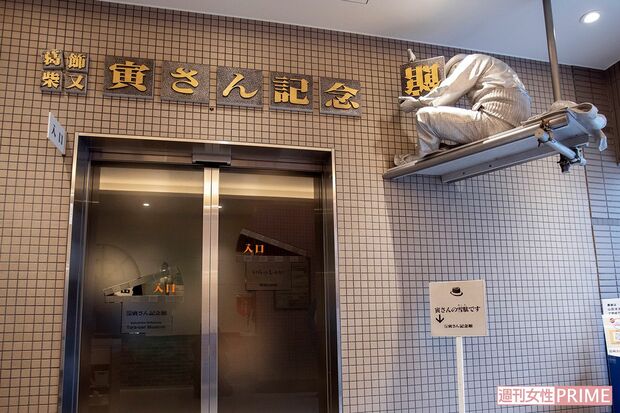 「寅さん記念館」で看板を取りつける寅さん像　撮影／齋藤周造