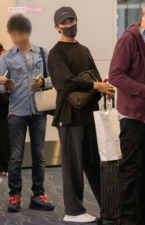 2023年11月、飛行機に搭乗する列に並ぶ赤西。手に持っている紙袋は、愛する家族へのお土産だろうか