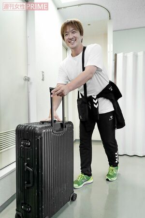 「すみません」と酒井は、会場に持ち込んだキャリーバッグを手にこれから公演へ　撮影／佐藤靖彦