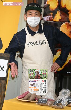 自身の焼き芋店の前でポーズを取るやまもとまさみ