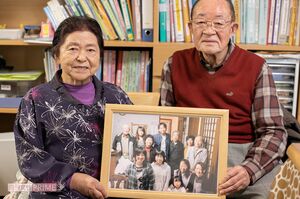 TOKIO城島が訪ねてきたときの写真を手にする孝子さん（左）と宝治さん夫妻