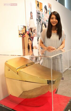 自身初のギャラリー展で推定700万円の「黄金トイレ」と記念撮影した植村花菜（2010年9月）