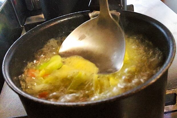 沸騰したら、アクを取って弱火にし、コンソメを加える