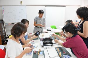 ワークショップで参加者たちに肌にも環境にもやさしい口紅作りを教える志奈さん。