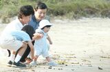 初めて訪れた須崎御用邸内の三井浜で遊ばれる生後8か月の愛子さま。雅子さまに支えられながらニコニコ笑顔で浜辺デビュー　写真／JMPA、『週刊女性』写真班