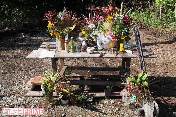 恩納村の死体遺棄現場に設けられた献花台。通りがかりに手を合わせていく人の姿も