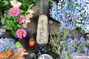 亡くなった渡邉さんの名前が書かれた石のまわりは花々で埋まっていた。慰霊に訪れる人があとを絶たないという