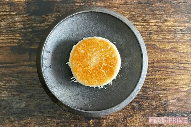 お皿にサラダのキャベツを盛り焼いた肉まんを置く