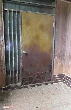 一部が剥がれかかっている玄関ドア