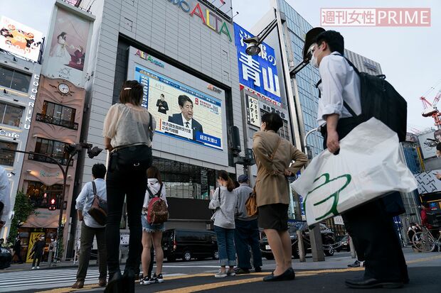 緊急事態宣言の解除を発表する安倍晋三首相の記者会見に聞き入る人々（新宿・アルタ前）