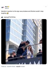 「ママと結婚して」と書かれたカードを指差すようにして爆笑する大谷夫妻（MLB公式Xより）