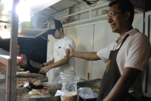 メキシコでタコス屋をしていた時のタカさん（写真奥）