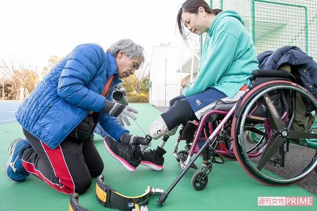 城戸彰子さんの生活用義足を、スポーツ義足に慣れた手つきでつけ替える臼井さん　撮影／伊藤和幸