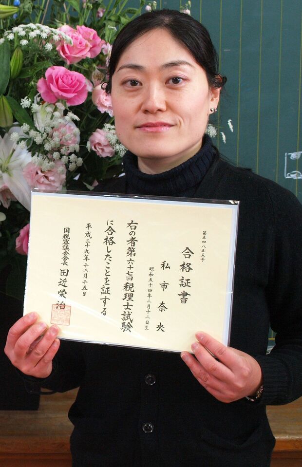 税理士の合格証書を持って