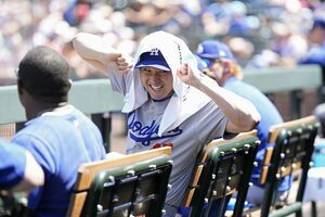 日本時間2025年8月22日、ベンチでリラックスして笑顔を見せる大谷翔平/共同通信