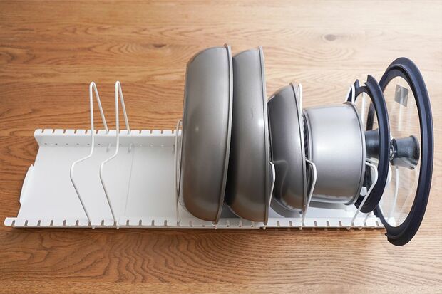 伸縮ざるボウルフライパンスタンド「鍋と鍋ぶたはこちらに収納。仕切り位置を変えられるので倒れず、真上から全貌が見渡せるのも便利」1790円／ニトリ　写真／フジモリタイシ、ヒラヤマタイジロー（『スキマをうめる収納ルール』より）