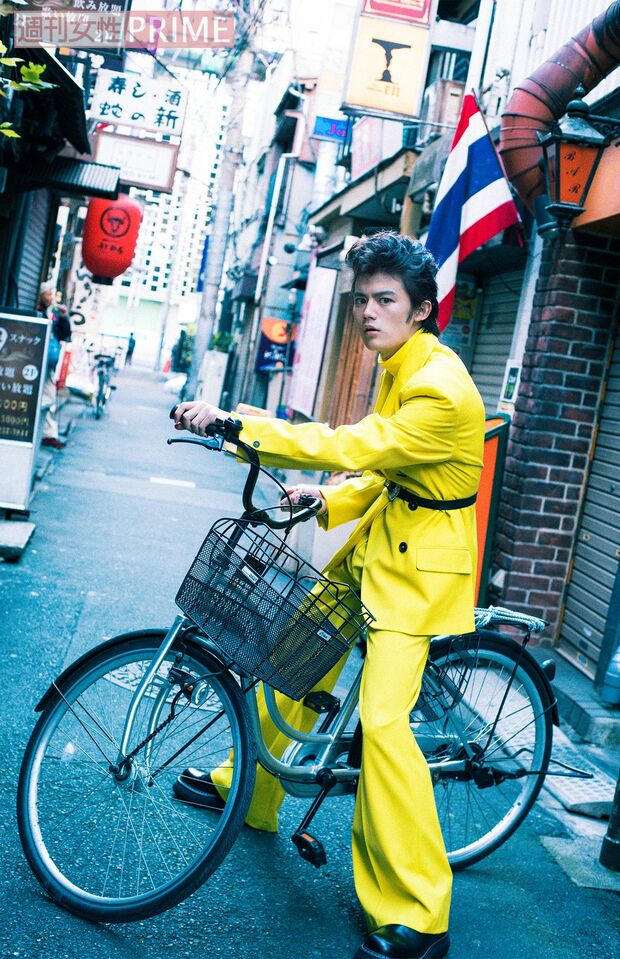 藤原大祐。月刊誌『JUNON』連載2年目のお気に入りショット。「ハイセンスなイエローのセットアップでママチャリに乗ったカットは、連載テーマのユーモアと違和感を象徴しているから」