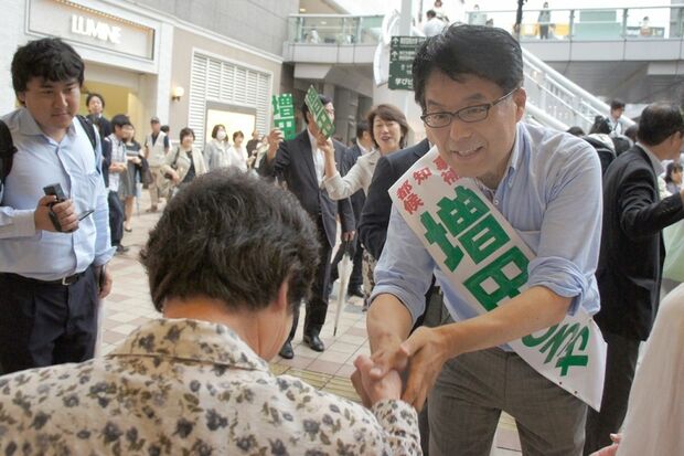 徒歩で移動中、年配の女性にササッと歩み寄って声をかける増田氏＝JR北千住駅前