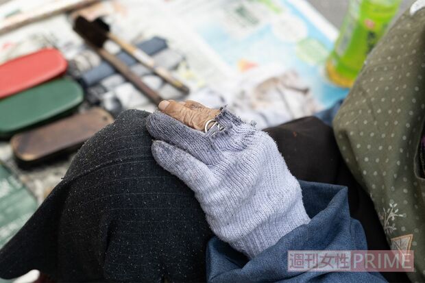 指先がカットされている手袋からのぞく真っ黒な指先で、靴を美しくよみがえらせる魔法をかける 