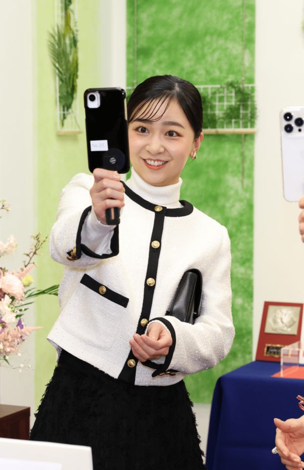 「第57回なるほど展」の視察は、白のタートルニットとジャケットに黒のロングスカートを合わせたモノトーンの装いで（2026年3月2日）