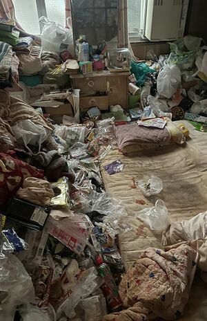 寝る場所だけ残して、あとは床が見えないほどのゴミの山。布団には遺体から染み出た体液の跡が　画像提供／グッドサービス