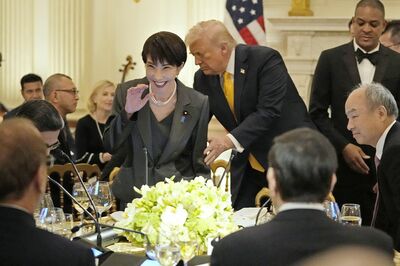 日米首脳会談後の夕食会で、トランプ大統領のエスコートで着席する高市早苗首相（日本時間3月20日、共同通信社）