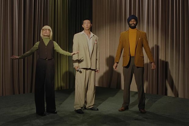 『LOST！』PVでTVショー司会者を演じるタズ・シン（右）とBTS・RM（中央）