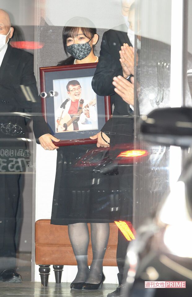 仲本工事さんの葬儀で遺影を持つ妻の純歌