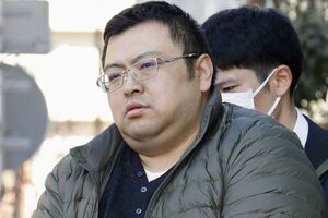 捜査員に連れられ、自宅マンションを出る細谷健一容疑者　写真/共同通信社