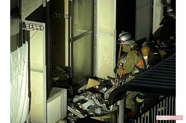 鎮火後、延焼を防ぐため田原春貴之容疑者宅から掻き出されたゴミを片付ける消防隊員（目撃者提供）