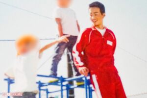 ジャングルジムの上で子どもたちと笑顔を浮かべる堀容疑者（卒業アルバムより）