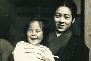 子どものころ、母に抱かれて。末っ子で、引っ込み思案な性格だった